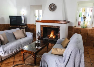 Imagen de salón con chimenea encendida de la villa del arco de la Casa rural San Antonio - casaruralsanantonio.es